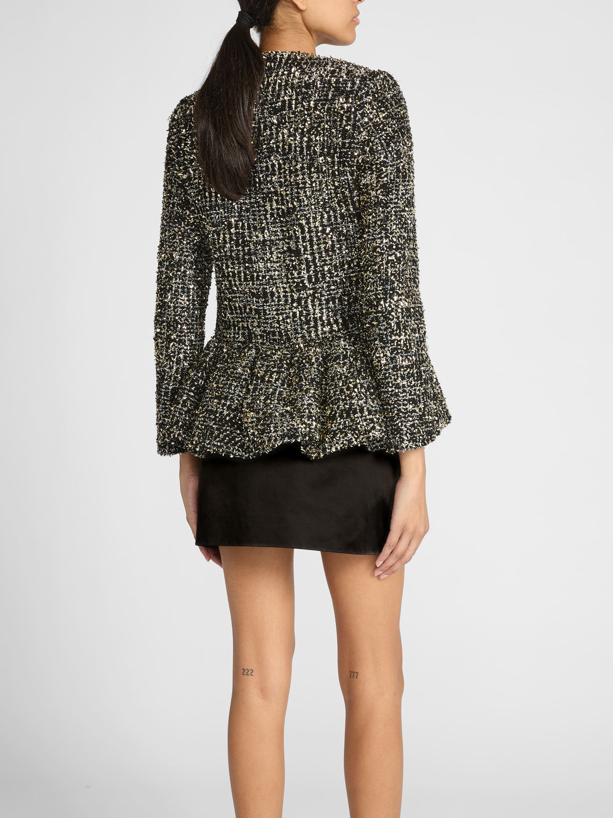 Woman wearing Liberowe black tweed Raja jacket buttoned with tailored trousers