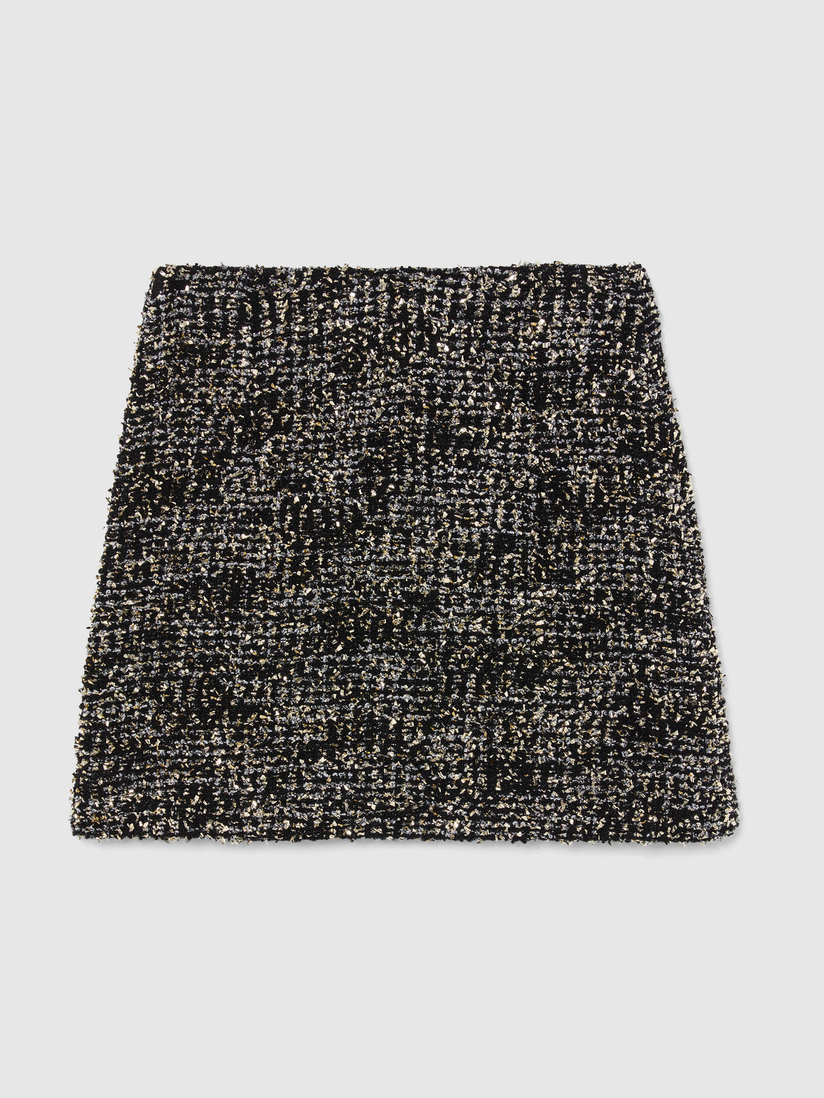 Crafted from textured bouclé tweed, the Vera Mini Skirt features a high-waisted silhouette woven from black and silver yarns with subtle gold metallic flecks throughout, bringing an understated glamour to any occasion.
