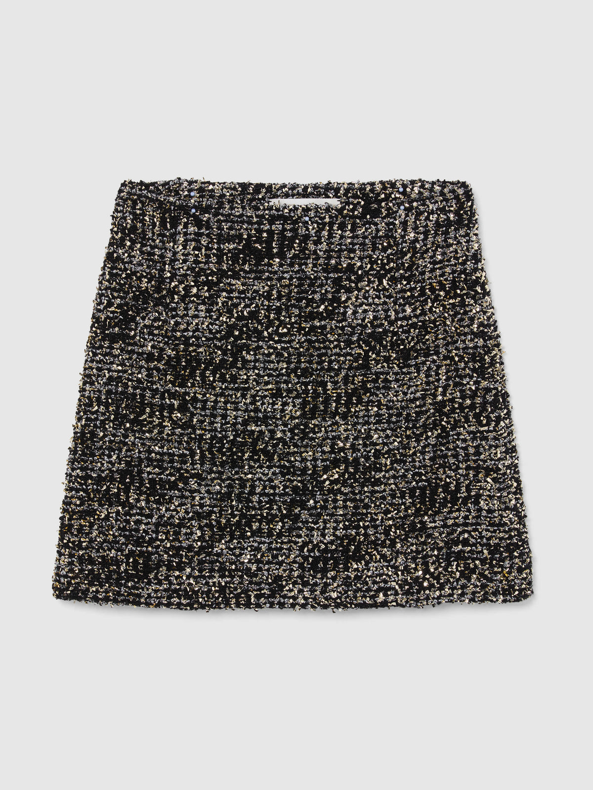 Crafted from textured bouclé tweed, the Vera Mini Skirt features a high-waisted silhouette woven from black and silver yarns with subtle gold metallic flecks throughout, bringing an understated glamour to any occasion.
