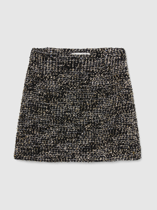 Crafted from textured bouclé tweed, the Vera Mini Skirt features a high-waisted silhouette woven from black and silver yarns with subtle gold metallic flecks throughout, bringing an understated glamour to any occasion.