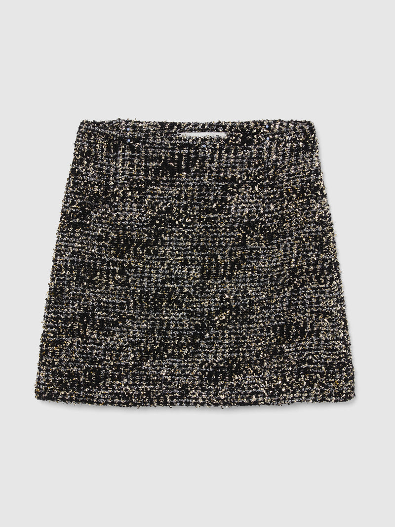 Crafted from textured bouclé tweed, the Vera Mini Skirt features a high-waisted silhouette woven from black and silver yarns with subtle gold metallic flecks throughout, bringing an understated glamour to any occasion.