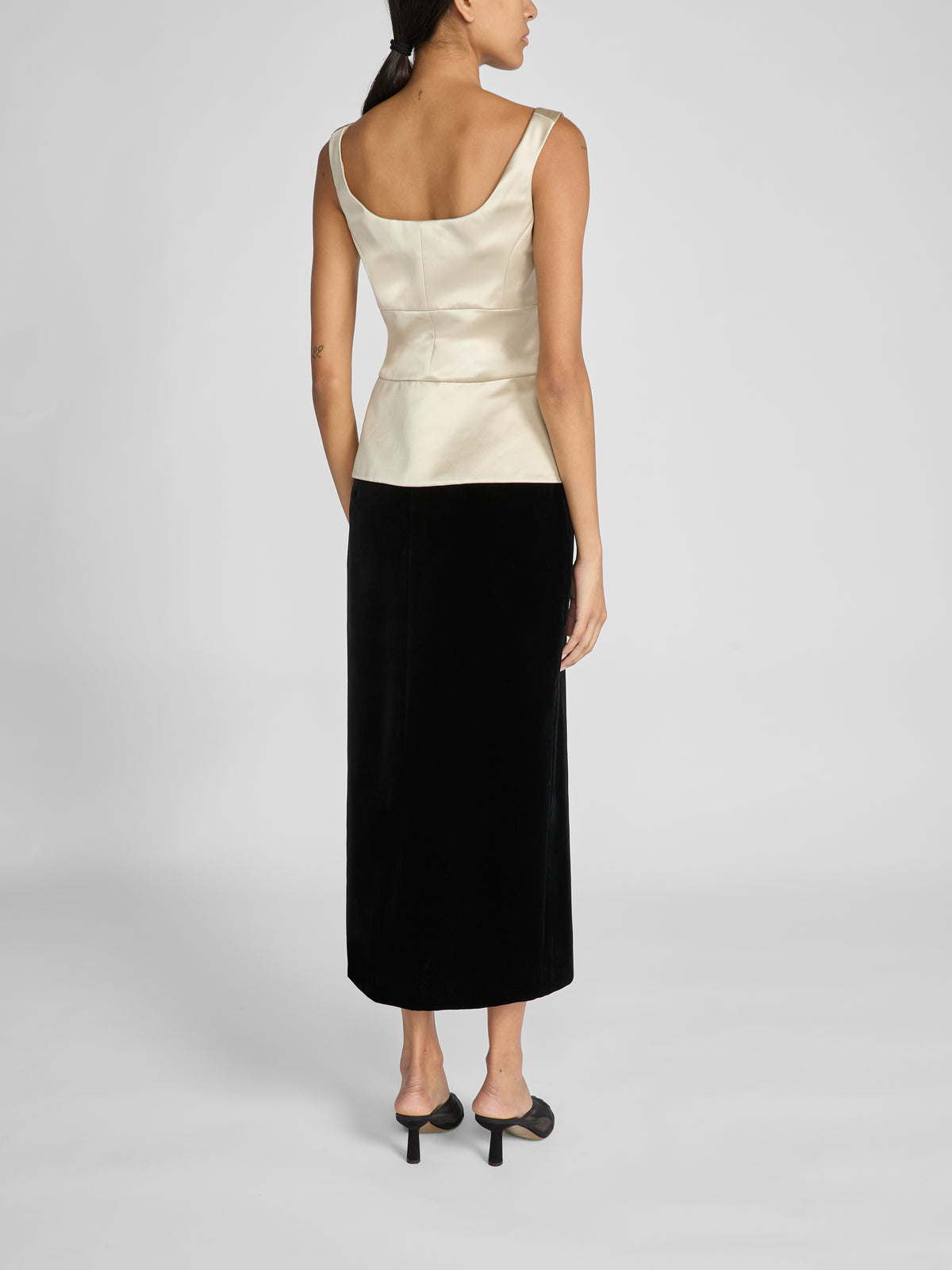 Crafted from luxurious black cotton velvet, the Rory Skirt is a high-waisted tailored midi skirt designed in a sleek column silhouette for a flattering shape before falling straight to mid-calf.