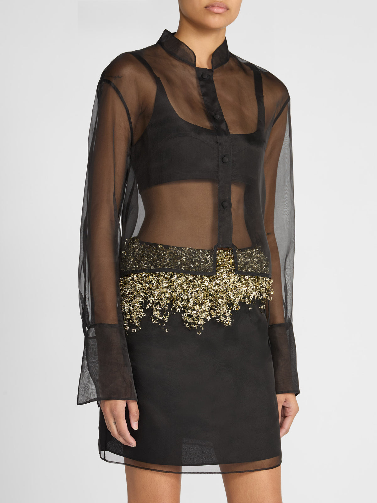 Crafted from sheer black silk, the Gold Fringe Skirt features a mini silhouette layered over a sleek slip lining, bringing effortless glamour to evening and occasion dressing.