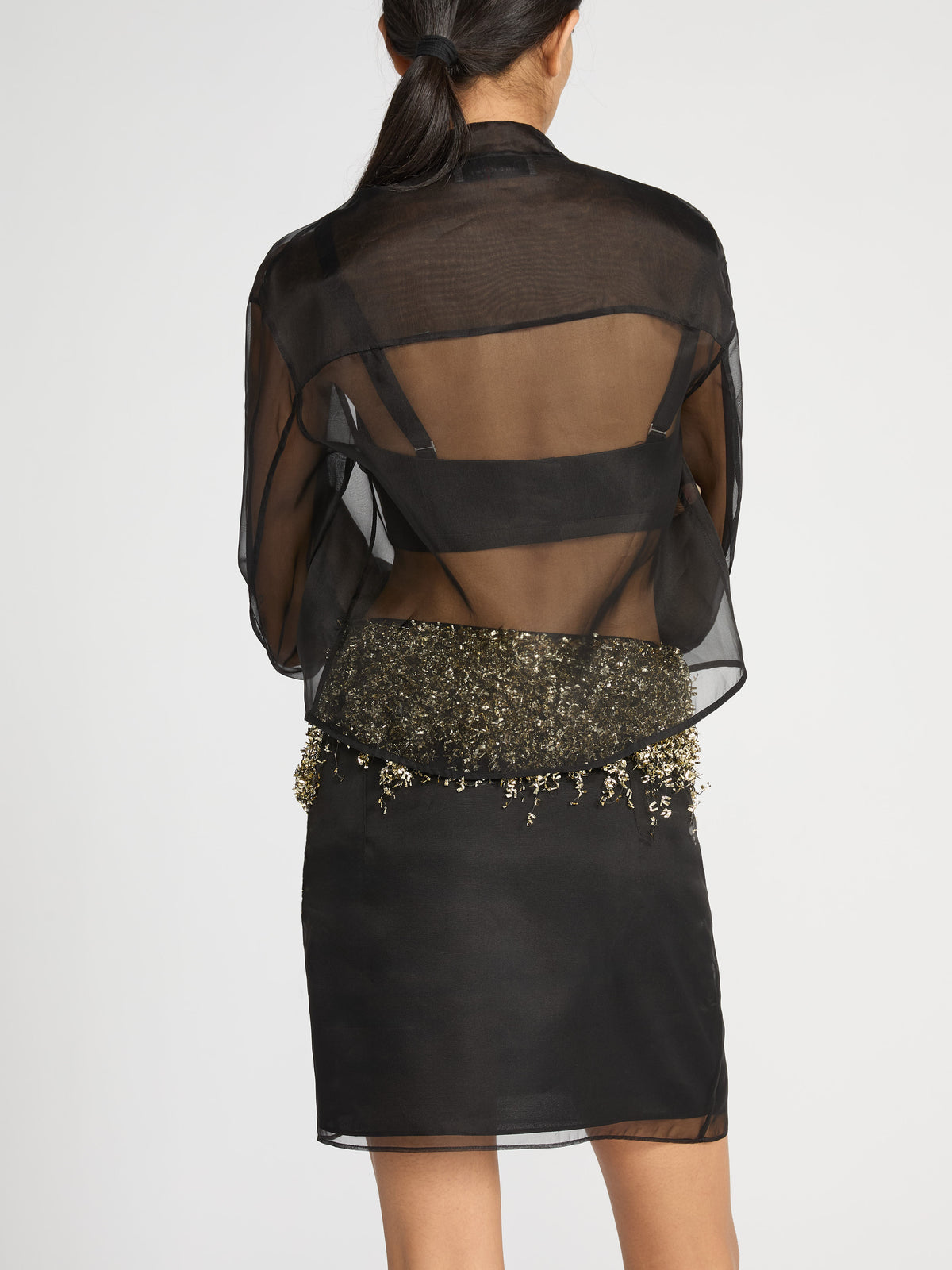 Crafted from sheer black silk, the Gold Fringe Skirt features a mini silhouette layered over a sleek slip lining, bringing effortless glamour to evening and occasion dressing.