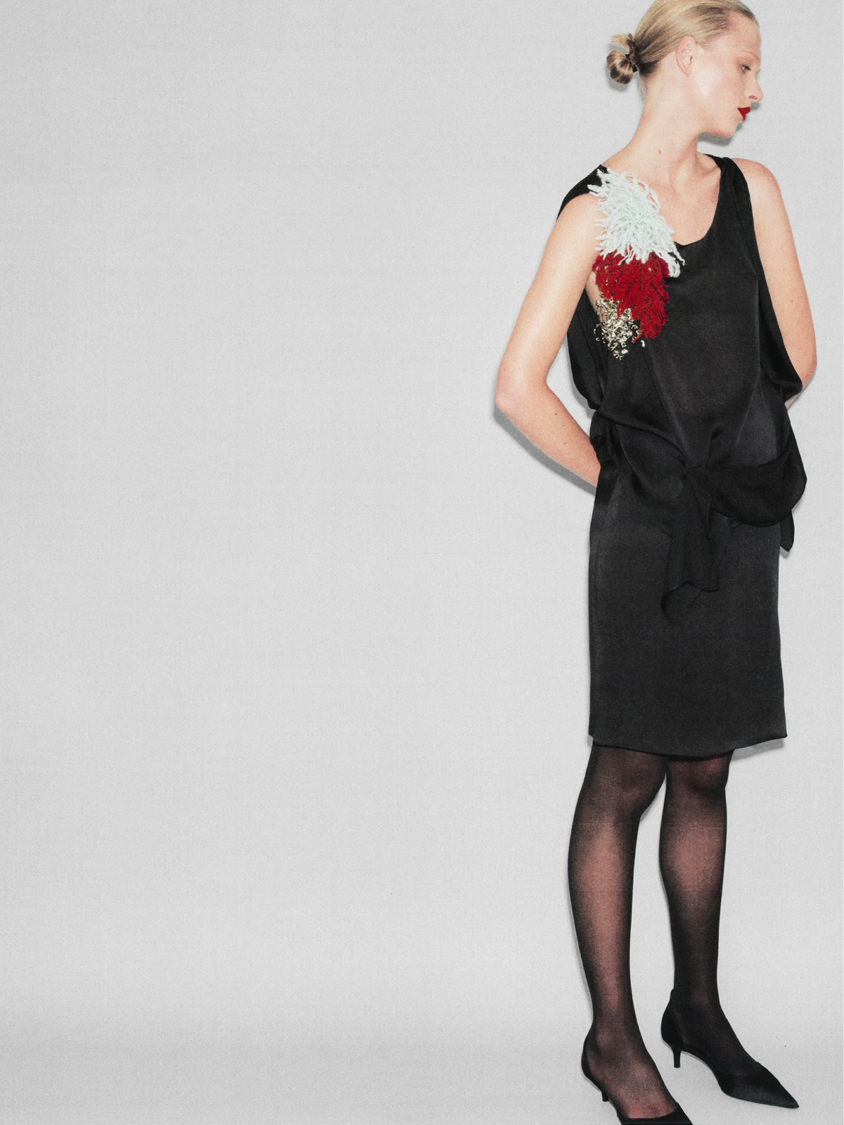 A model wearing a a sleek straight-cut silhouette, it sits elegantly at the waist with a narrow waistband and tailored darts for a clean, flattering shape. Perfect for elevated everyday and occasion dressing. with matching sleeveless top Crafted from fluid black silk,  features a softly draped bodice and elegant scoop neckline, creating a graceful, feminine silhouette.